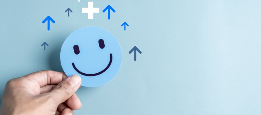 Smiley face on blue background with upward arrows symbolizing positivity.